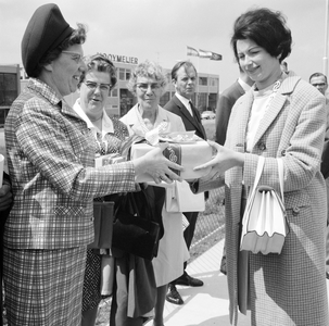 171879 Afbeelding van de overhandiging van een doos met gratis treinkaartjes door N.S.-ambassadrice Jeanne Vollemans ...